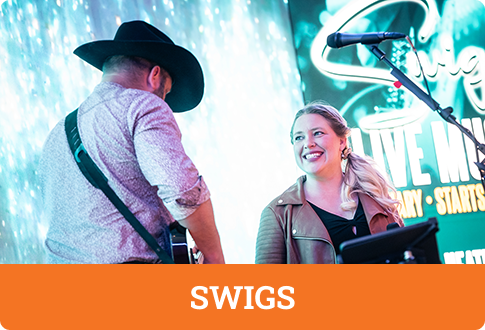 Two musicians perform at Swigs