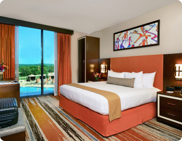 Hotel room at Osage Casino Tulsa featuring a king bed and pool view.